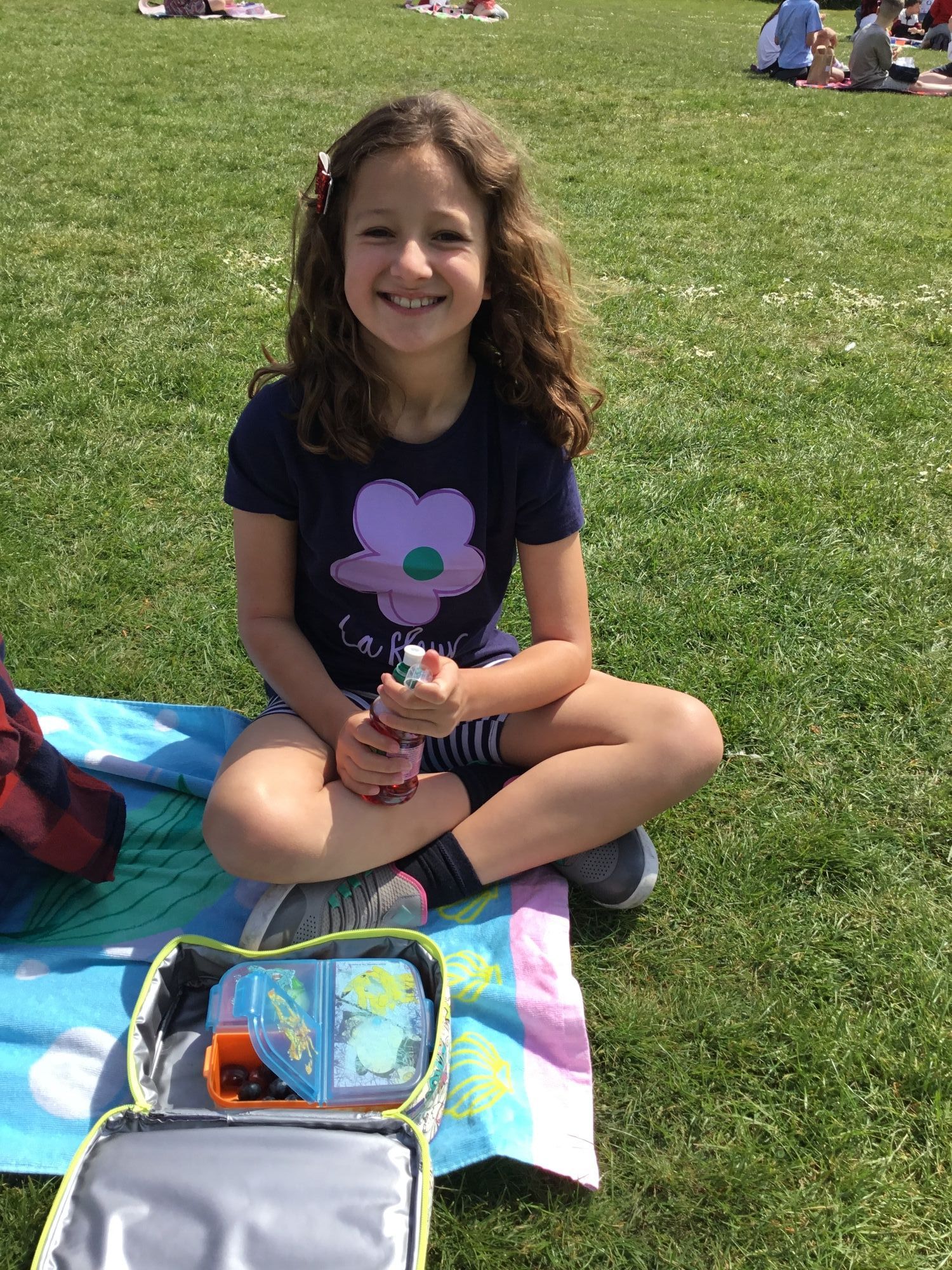 Child on the field enjoying their picnic.