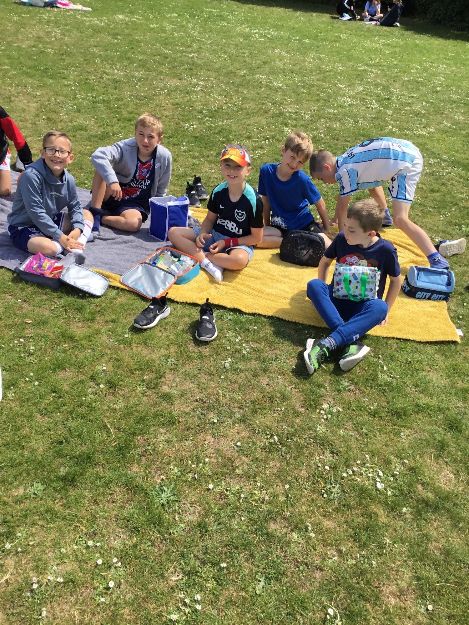 Children on the field enjoying their picnic.