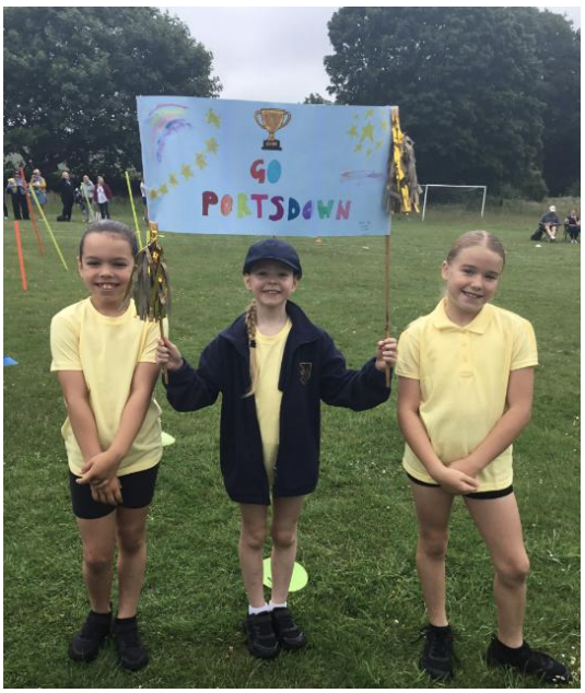 3 girls holding a sports day banner