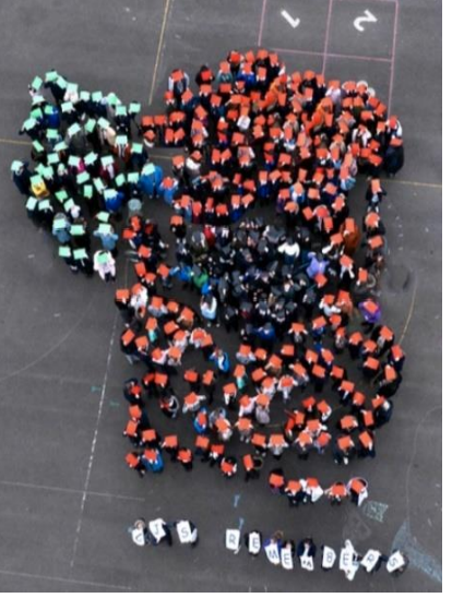 Children making a poppy shape on the playground