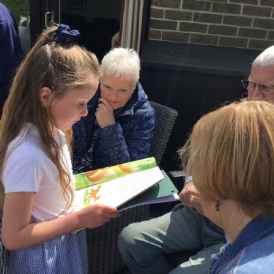 Child is reading to a resident