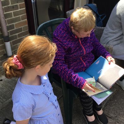 Child reading to resident